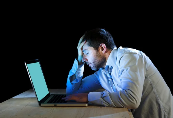 Worker exhausted in front of laptop